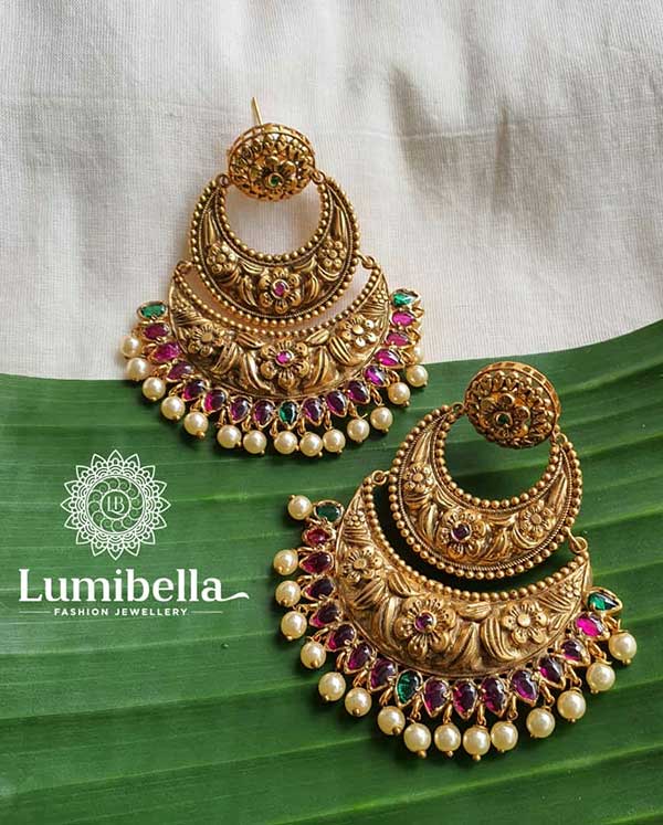 Big AD Chandbali Earrings has floral designs on the top. Floral designs are studded with green stones. It is connected to chandbali design engraved with floral design. Floral designs are bedecked with ruby stone. Another chandbali design follows it and has pear designs below it. Pear designs are festooned with ruby and green stones. These Beautiful Ad Chandbali Earrings are a nice accessory to sport with your ethnic wear.
